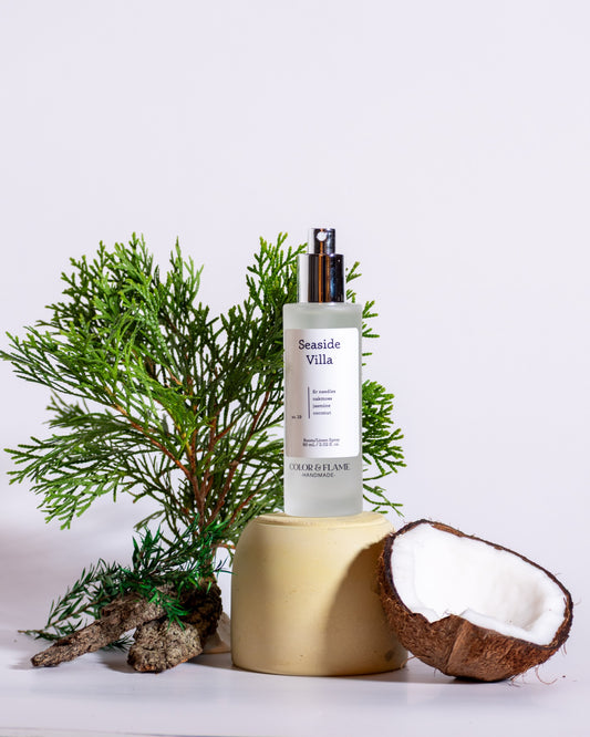 Color & Flame Handmade Seaside Villa room and linen spray styled with evergreen branches, bark, and coconut.