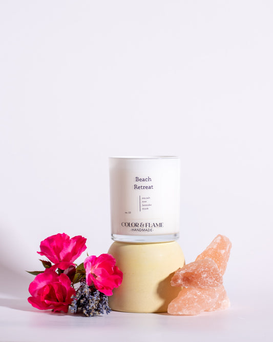 Color & Flame Handmade Beach Retreat candle styled with pink roses, lavender, and pink salt crystals.
