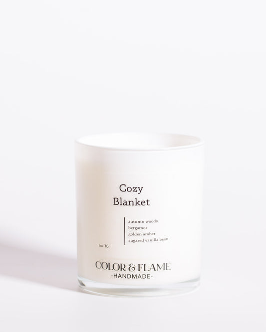 Color & Flame Handmade Cozy Blanket Core Collection candle in a white glass jar.
