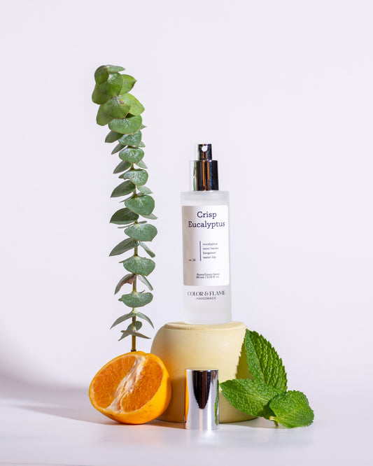 Color & Flame Handmade Crisp Eucalyptus room and linen spray styled with eucalyptus, mint leaves, and orange.

