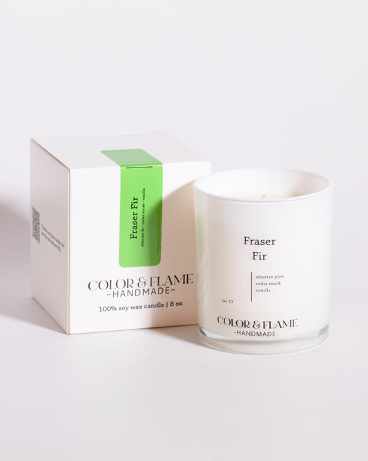Color & Flame Handmade Fraser Fir Core Collection candle displayed beside its white box.
