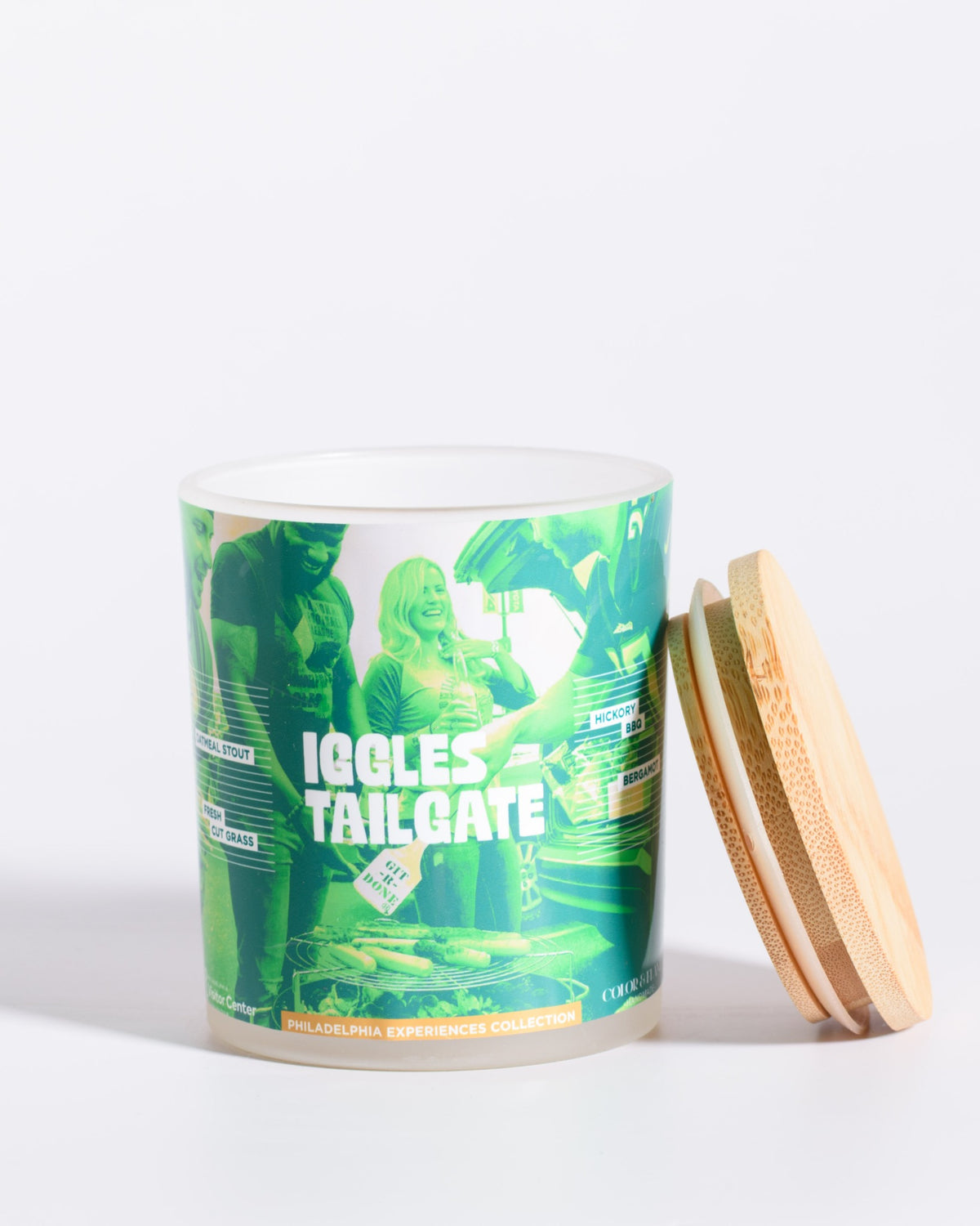 Color & Flame Handmade Iggles Tailgate Philadelphia Experiences candle shown open with its bamboo lid beside the jar.

