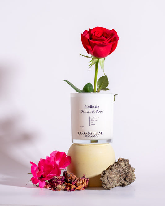 Color & Flame Handmade Jardin de Santal et Rose candle styled with a red rose, pink roses, dried rose petals, and wood.
