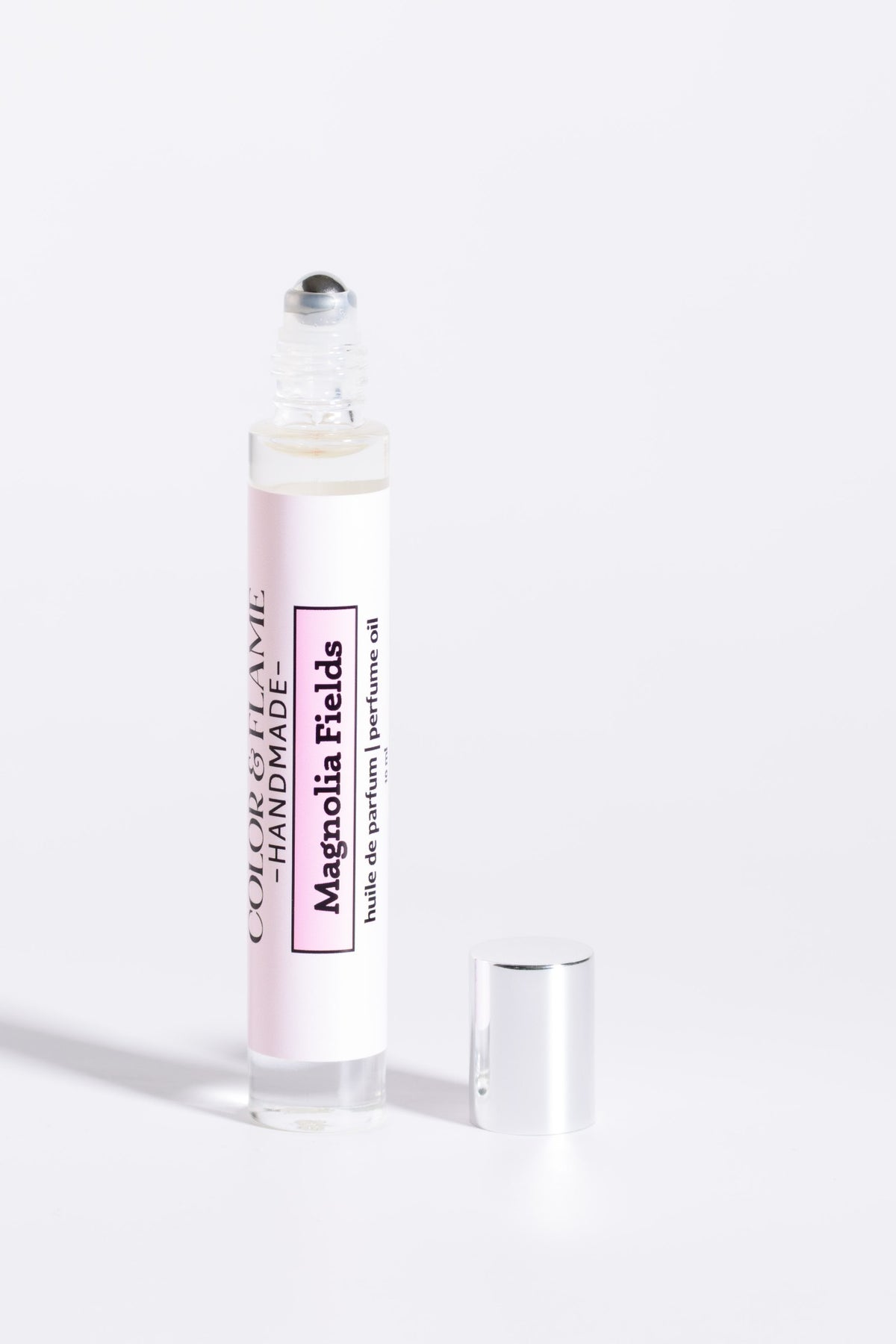 Color & Flame Handmade Magnolia Fields 10 ml perfume oil with cap removed to show the rollerball.
