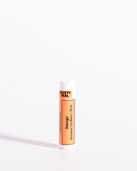 Color & Flame Handmade Mango beeswax lip balm in a white tube with an orange label.