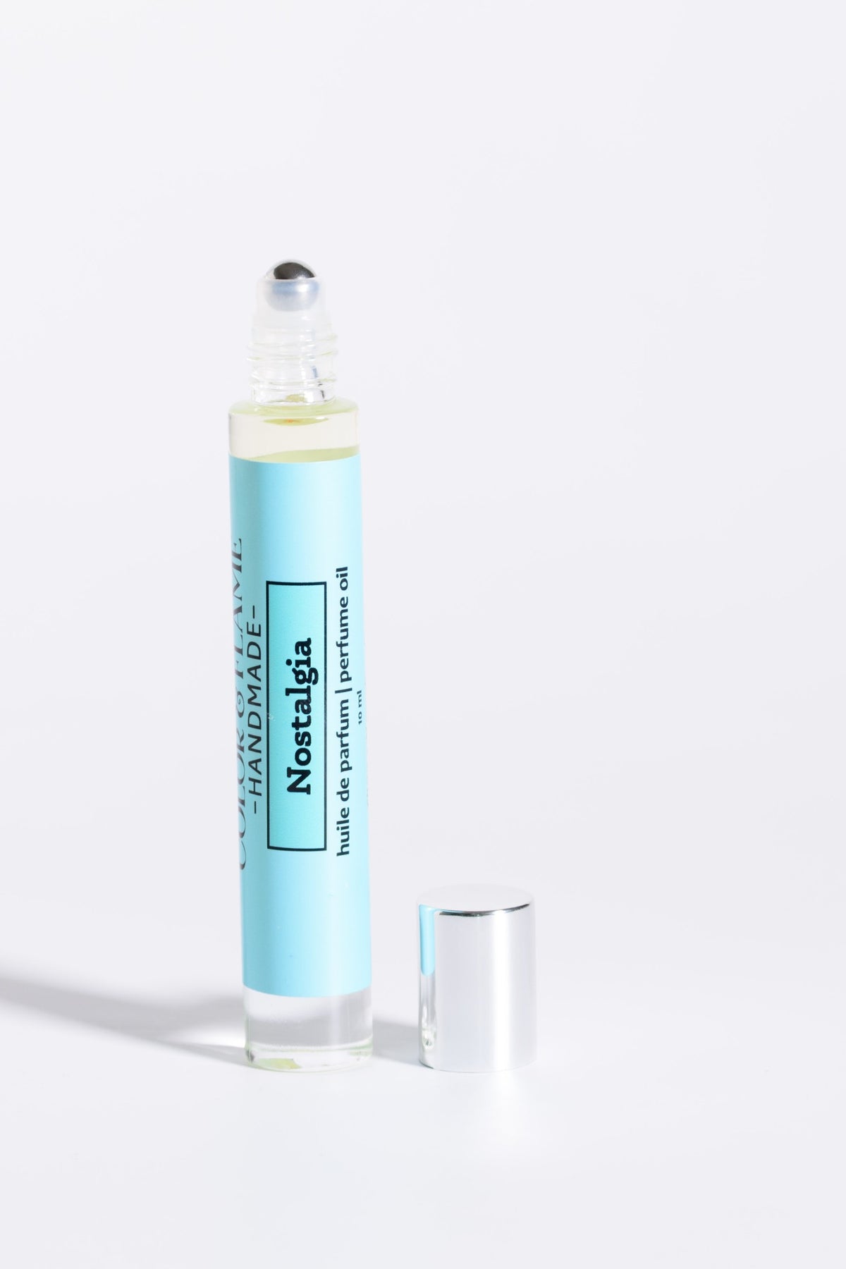 Color & Flame Handmade Nostalgia 10 ml perfume oil with cap removed to show the rollerball.
