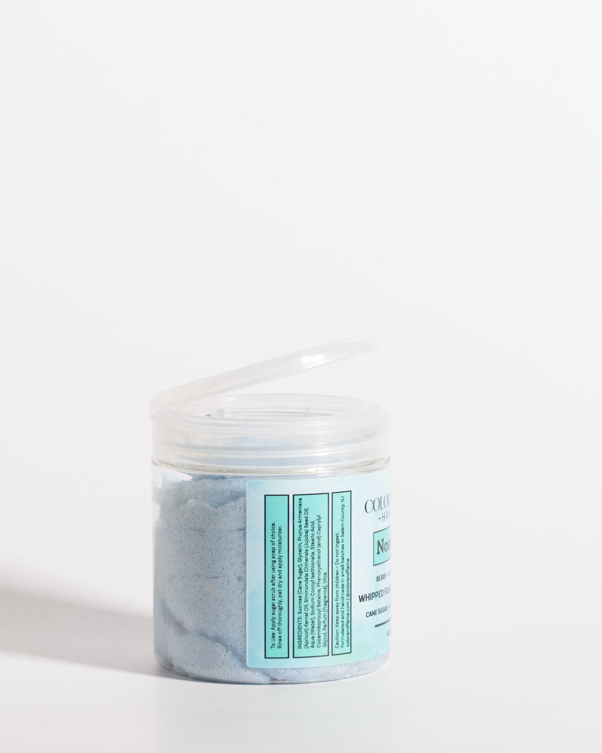 Color & Flame Handmade Nostalgia whipped foaming sugar scrub in an open clear jar showing the blue scrub.
