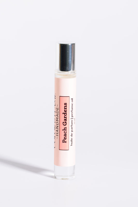 Color & Flame Handmade Peach Gardens 10 ml roll-on perfume oil with its silver cap attached.
