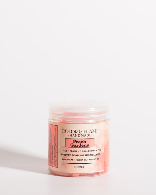 Color & Flame Handmade Peach Gardens whipped foaming sugar scrub in a clear jar with a peach-colored label.

