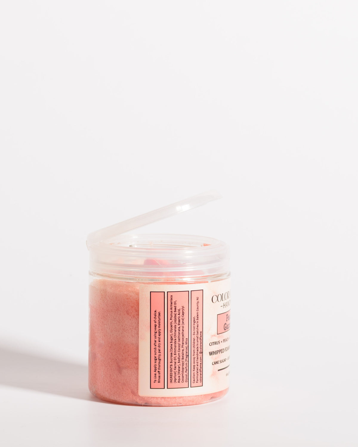 Color & Flame Handmade Peach Gardens whipped foaming sugar scrub in an open clear jar showing the peach-colored scrub.
