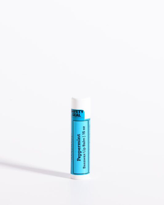 Color & Flame Handmade Peppermint beeswax lip balm in a white tube with a blue label.