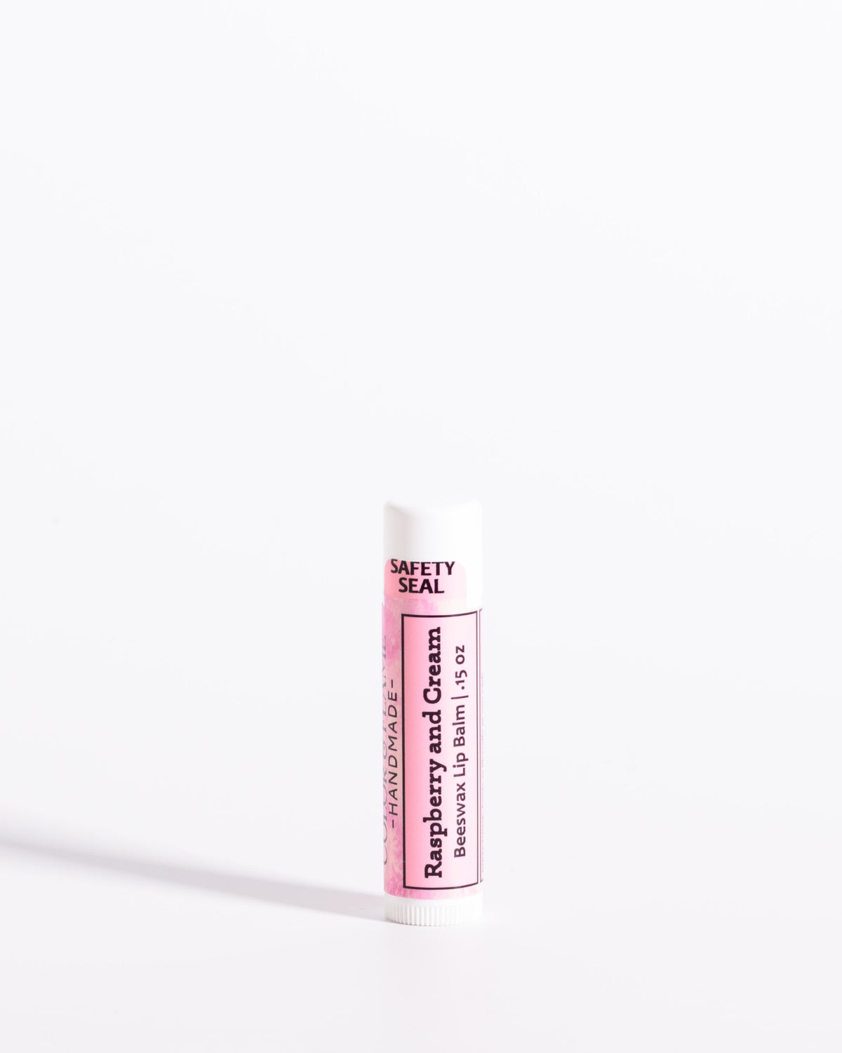 Color & Flame Handmade Raspberry and Cream beeswax lip balm in a white tube with a pink label.