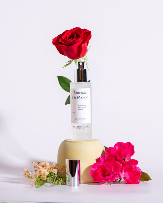 Color & Flame Handmade Roseraie à la Maison room and linen spray styled with red and pink roses and dried flowers.
