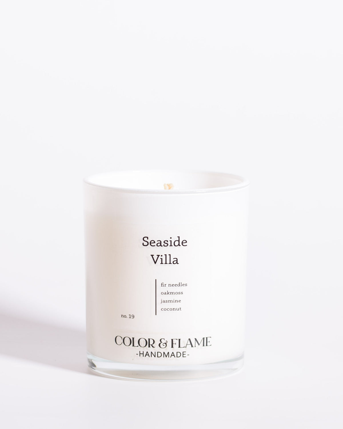 Color & Flame Handmade Seaside Villa Core Collection candle in a white glass jar.
