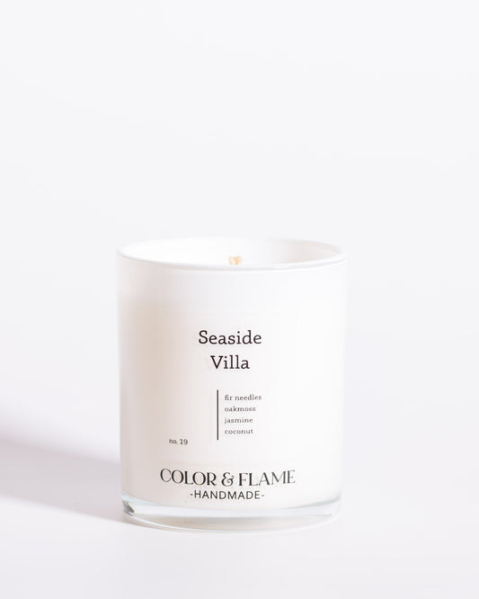 Color & Flame Handmade Seaside Villa Core Collection candle in a white glass jar.
