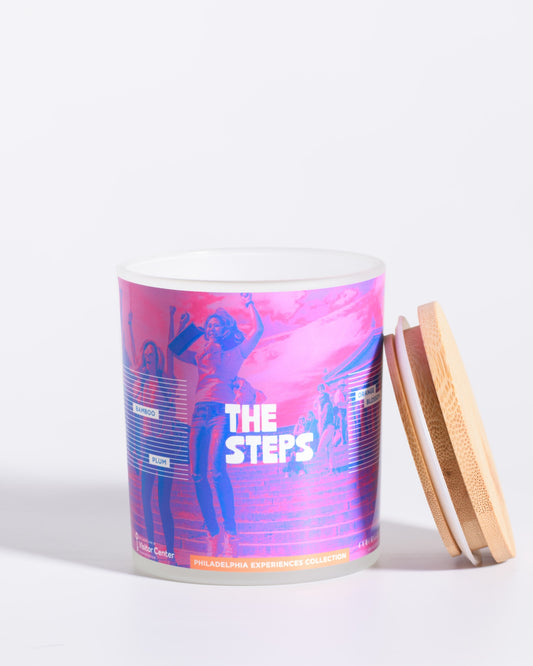 Color & Flame Handmade The Steps Philadelphia Experiences candle shown open with its bamboo lid beside the jar.
