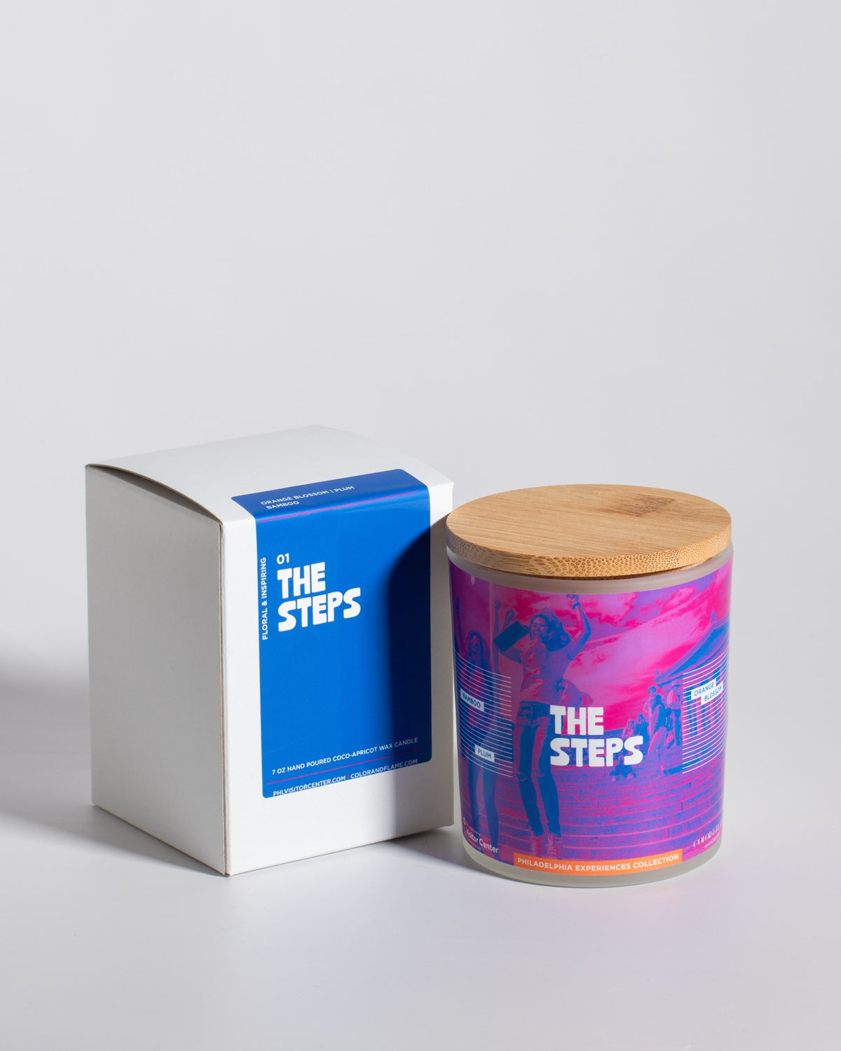 Color & Flame Handmade The Steps Philadelphia Experiences candle displayed beside its white box.
