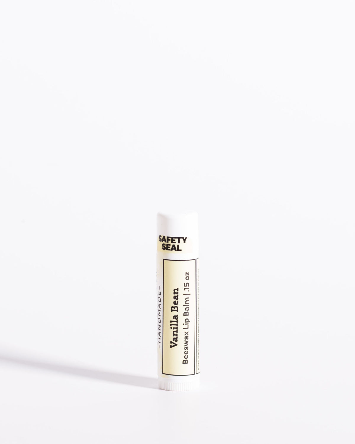 Color & Flame Handmade Vanilla Bean beeswax lip balm in a white tube with a cream label.